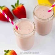 strawberry banana smoothie in glass jars with pink and white straws