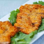 Japanese tonkatsu cut up on kale in the long white plate