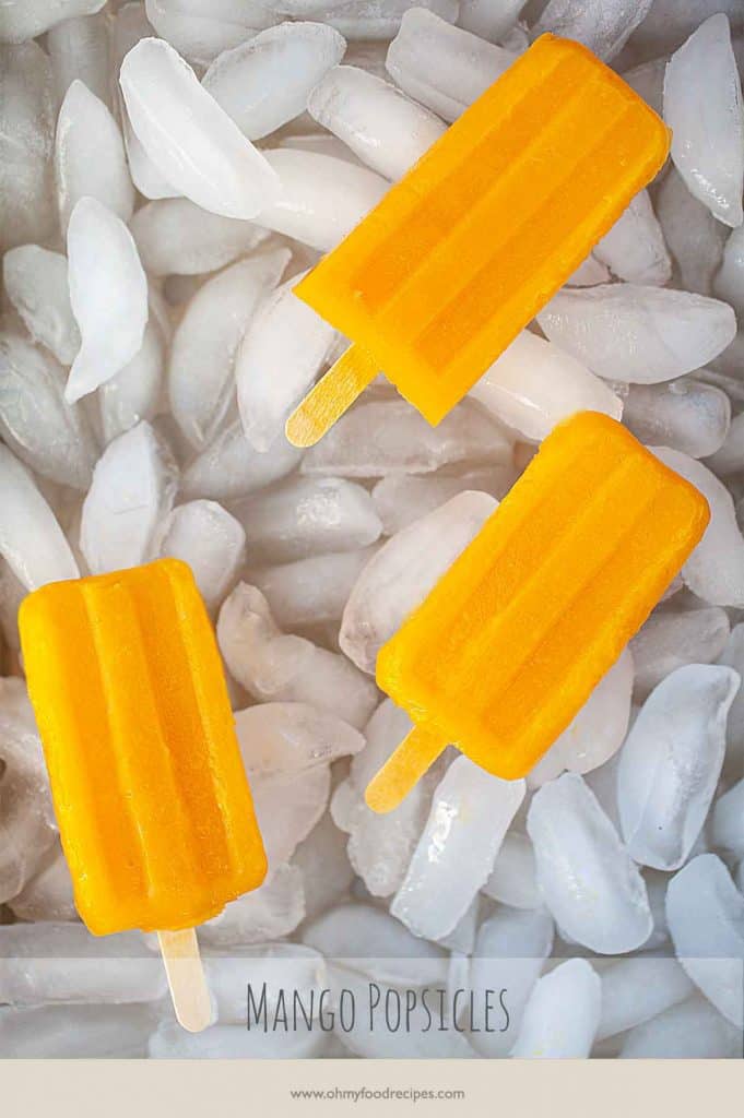 homemade fresh mango popsicles on a tray with ice