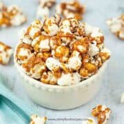 homemade caramel popcorn in the bowl with a towel at the background
