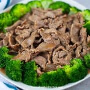 Chinese authentic beef and broccoli on the plate with a striped blue towel