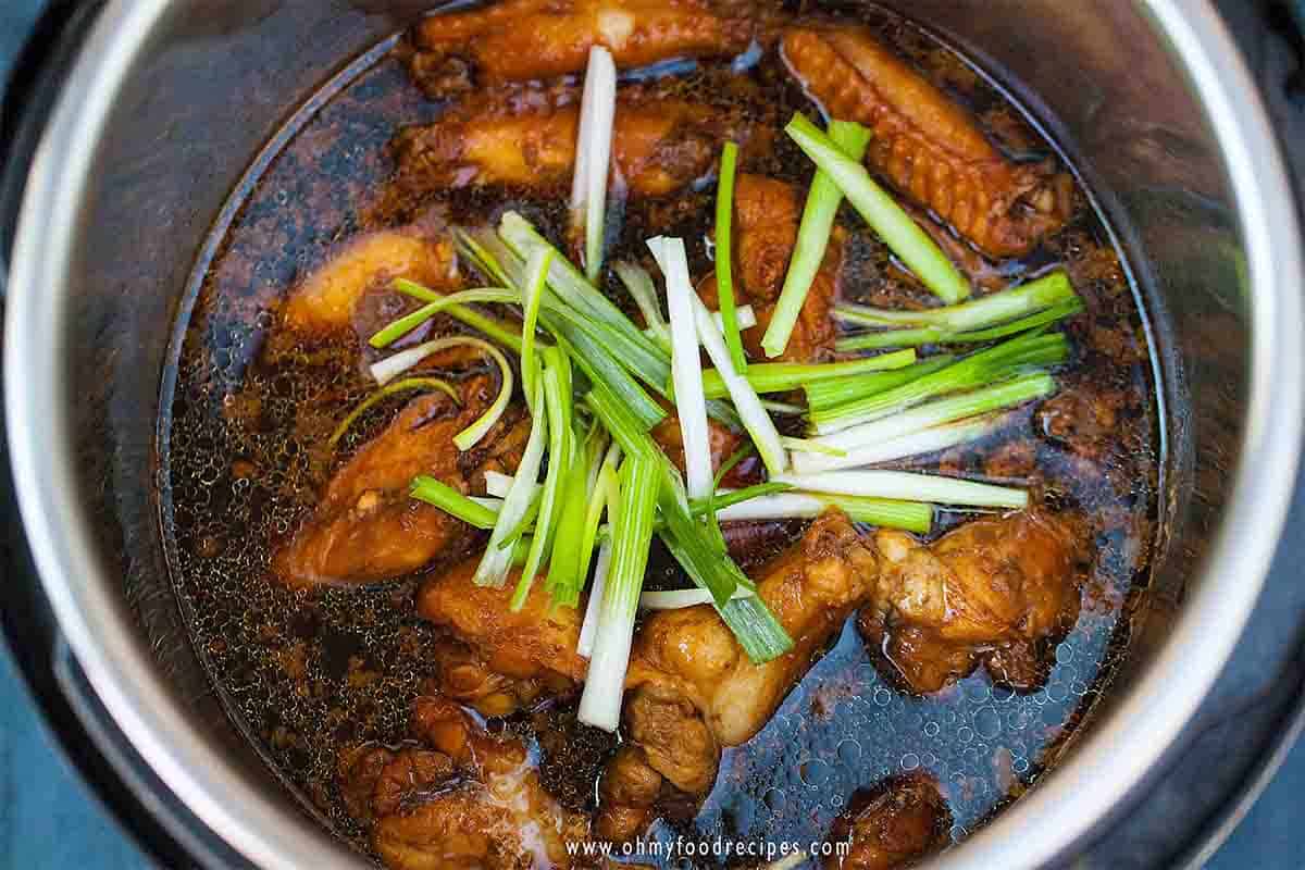 cooked soy sauce chicken wings in the instant pot with green onion on top