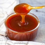 homemade Chinese sweet and sour sauce on a spoon dripping the sauce
