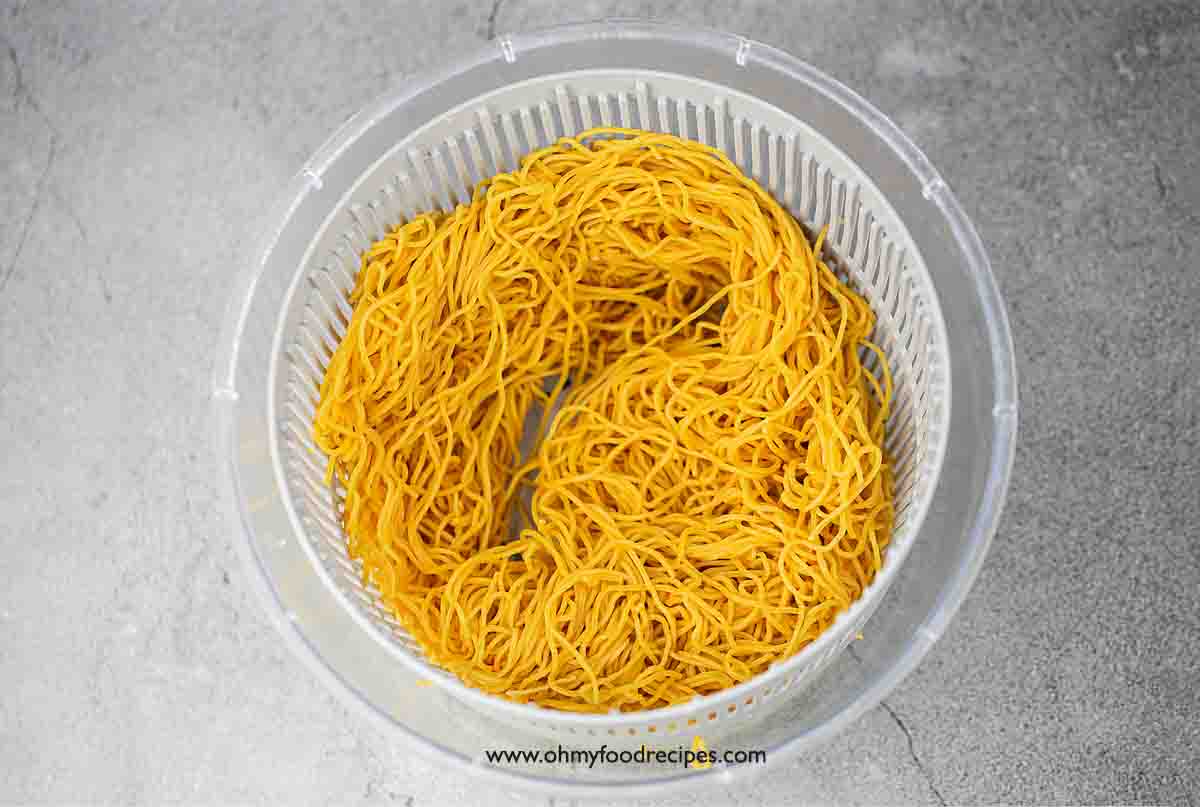 cooked and drained noodles in salad spinner top view