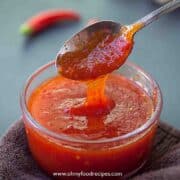 homemade Thai sweet chili sauce on spoon dripping down