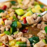 Chinese kung pao chicken on the silver spoon close up
