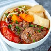 Taiwanese beef noodle soup with a striped towel and chopsticks