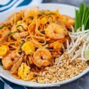 easy homemade pad thai noodle dish with peanuts garlic chives bean sprouts and lime on the side of the dish