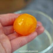 salted duck yolk on hand close up
