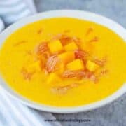 mango pomelo sago dessert in the bowl with a striped gray white towel