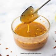 Thai peanut sauce drip down from the spoon horizontal