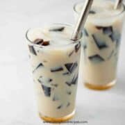 two glasses of grass jelly drink horizontal with straws