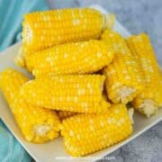 cooked corn on the cob on the white plate close up