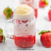 Korean strawberry milk in a glass jar with strawberries in the background