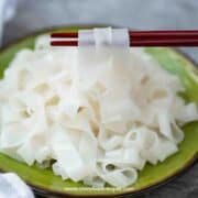 fresh homemade ho fun noodles on the chopsticks