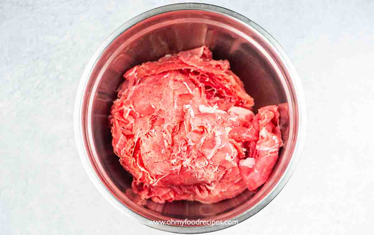 Thinly sliced beef in the bowl top view